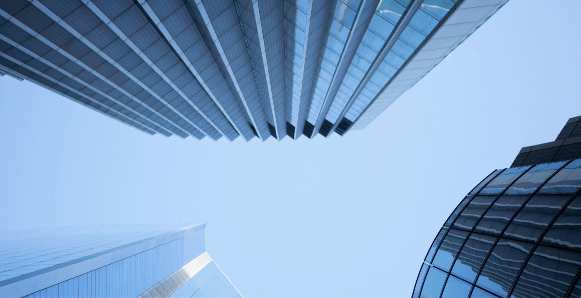 low angle of three office buildings with blue sky